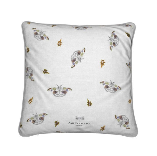 Cushion featuring a repeating moth pattern on a white background.