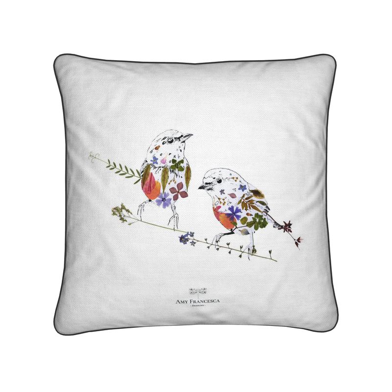 Cushion featuring two birds perched on branches on a white background.