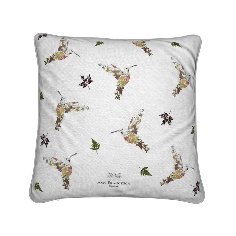 Cushion featuring a repeating hummingbird pattern on a white background.